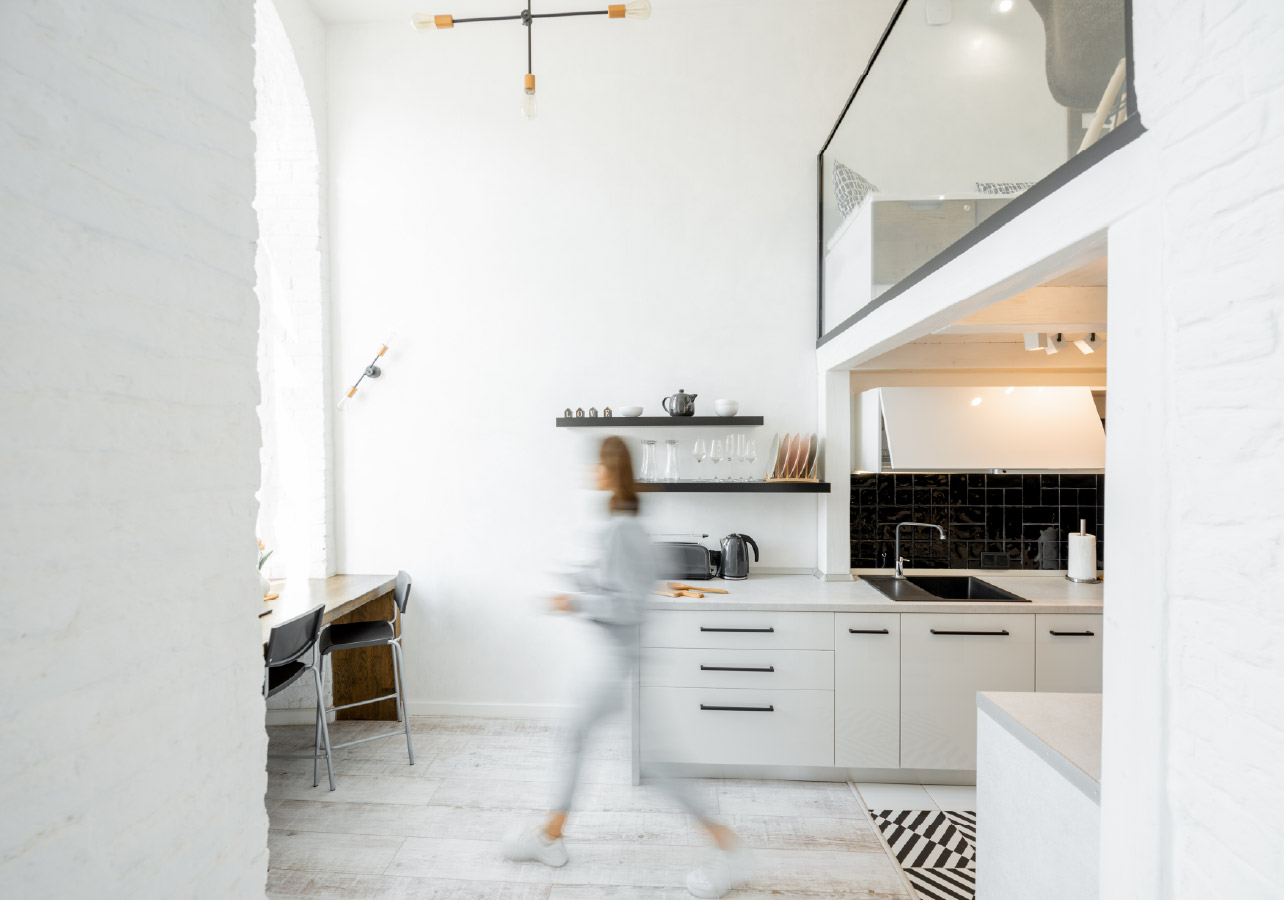 Blurred image representing motion showing a woman walking through her kitchen